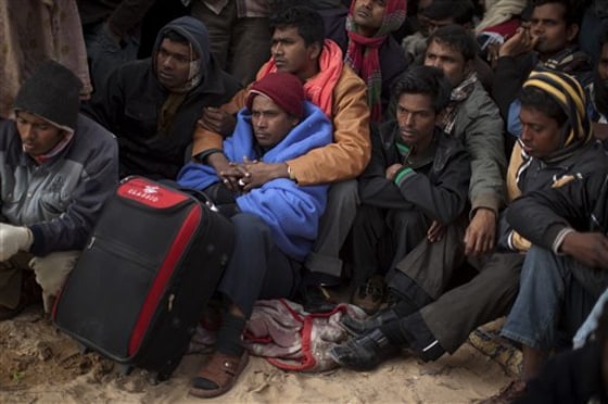 Men from Bangladesh, who worked in Libya but recently fled the unrest, wait for information during their repatriation process in a refugee camp at the Tunisia-Libyan border, in Ras Ajdir, Tunisia, on Saturday. Most Bangladeshis appear to have arrived in Tunisia penniless because their Libyan employers did not pay them or because they were robbed on the way.